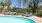 pool area with reclining seats and landscaping